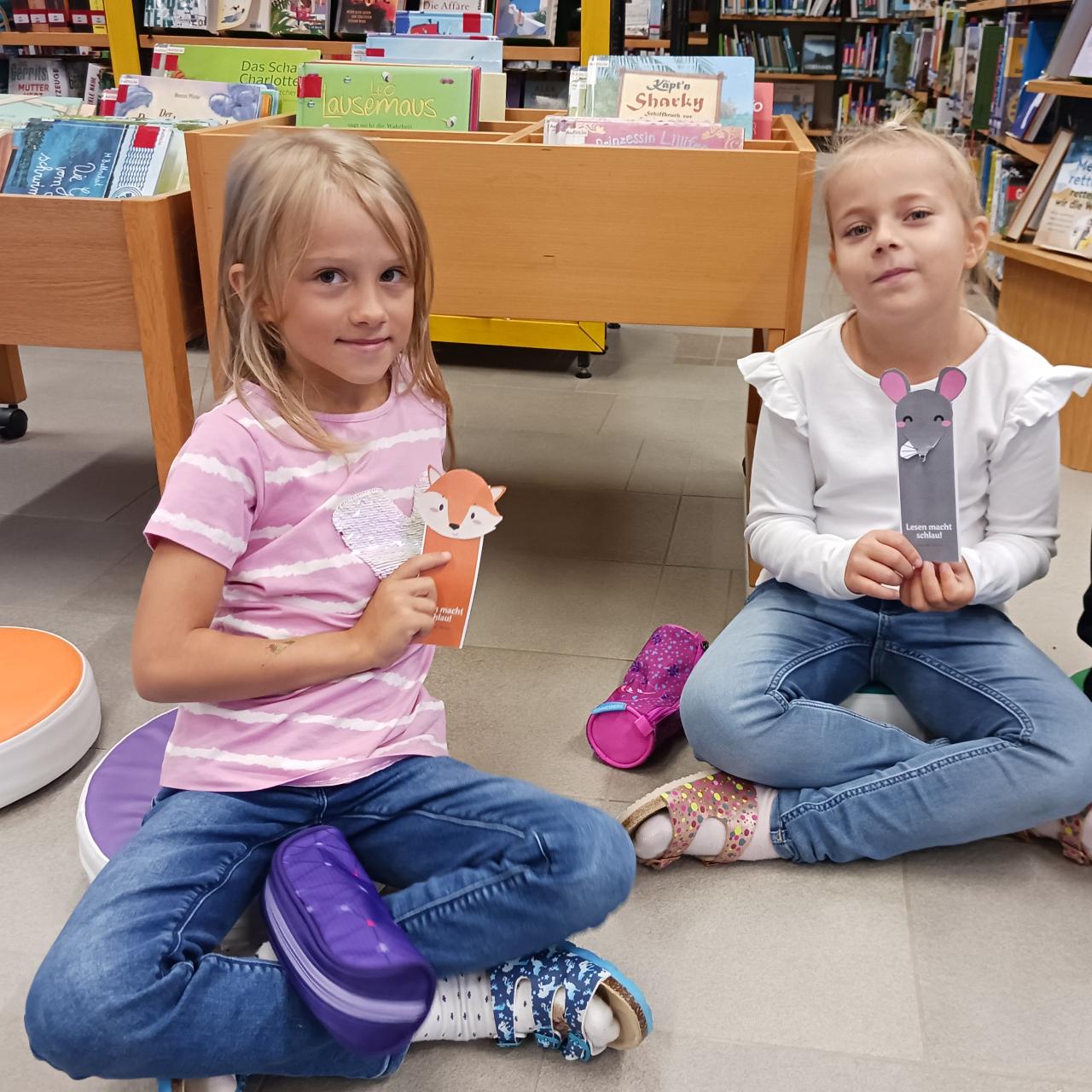 2 Mädchen mit Lesezeichen in Bibliothek
